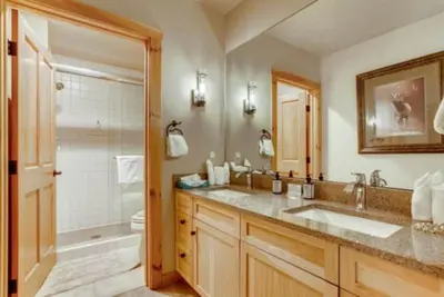 a bathroom with two sinks and a shower and a toilet at River Run Village 3 Bedroom Condo in Keystone