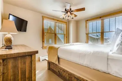 a bedroom with a bed and a tv and windows at River Run Village 3 Bedroom Condo in Keystone