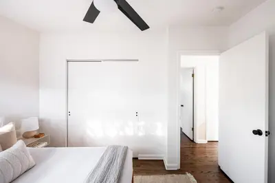 a white bedroom with a bed and white walls at Chic Mid-Century Home Near Olde Town Arvada in Arvada