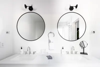 a white bathroom with two mirrors and a sink at Chic Mid-Century Home Near Olde Town Arvada in Arvada