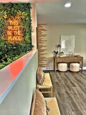 a living room with a wall with a sign that says this must be the palace at NEW: Tulum Oasis in Denver w/ Hot Tub & Games in Denver