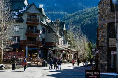 a group of people walking down a street in a ski resort at 8045 Black Bear condo in Keystone