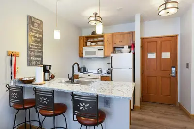 a kitchen with a counter and three bar stools at 8045 Black Bear condo in Keystone