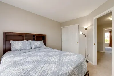 a bedroom with a large bed with a wooden headboard at Spacious Aurora Home 20 Mi to Downtown Denver! in Aurora