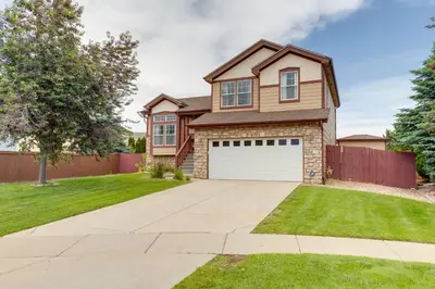 a house with a driveway and grass at Spacious Aurora Home 20 Mi to Downtown Denver! in Aurora