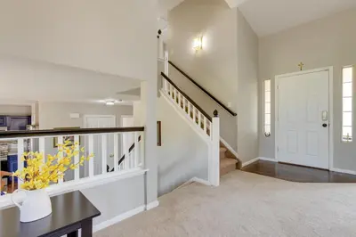 a home hallway with a staircase and a white door at Spacious Aurora Home 20 Mi to Downtown Denver! in Aurora
