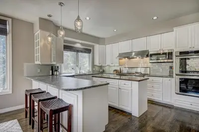 a kitchen with white cabinets and a large island with bar stools at 5 Ski Resorts within 16 Miles - Salt Water Hot Tub in Dillon