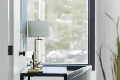 a table with a lamp on it next to a window at Keystone Lake - MTN View - Pool Hot Tub Gym Sauna in Dillon