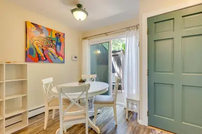 a dining room with a table and chairs and a green door at Beautiful Boulder Townhome Walk to CU and Pearl St! in Boulder