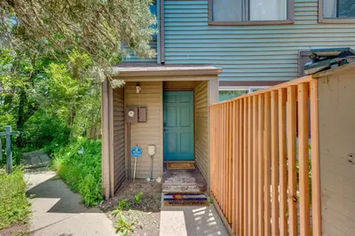 a house with a blue door and a fence at Beautiful Boulder Townhome Walk to CU and Pearl St! in Boulder