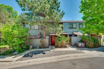 a house with a red door and trees at Beautiful Boulder Townhome Walk to CU and Pearl St! in Boulder