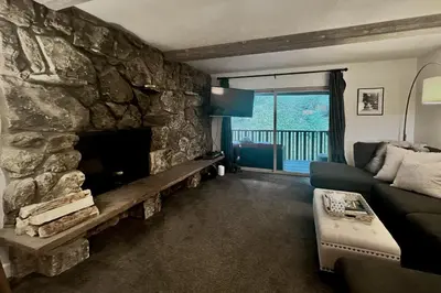 a living room with a stone fireplace and a couch at Mountain Vista Retreat in Winter Park