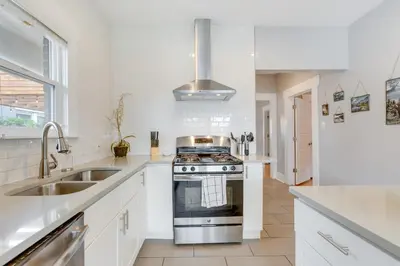 a white kitchen with a stove and a sink at Updated Denver Home about 3 Mi to Downtown! in Denver
