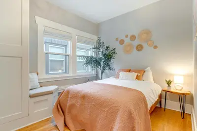 a bedroom with a large bed and two windows at Updated Denver Home about 3 Mi to Downtown! in Denver