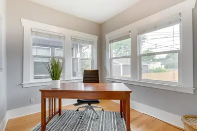 a home office with a wooden table and two windows at Updated Denver Home about 3 Mi to Downtown! in Denver