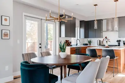 a kitchen and dining room with a wooden table and chairs at Luxe Getaway - Yard & Roof Deck - 4 Story Townhome in Denver
