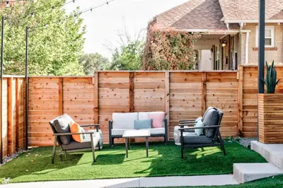 a backyard with two chairs and a table on grass at Luxe Getaway - Yard & Roof Deck - 4 Story Townhome in Denver