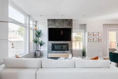 a living room with a white couch and a fireplace at Luxe Getaway - Yard & Roof Deck - 4 Story Townhome in Denver