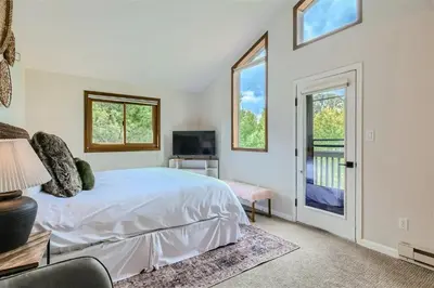 a white bedroom with a bed and a balcony at Hawn Drive 62 townhouse in Frisco
