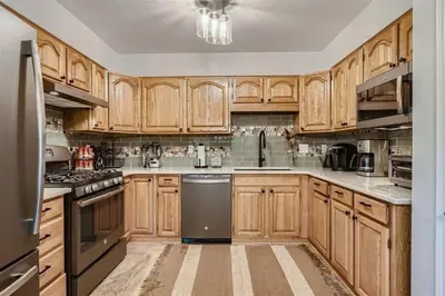 a large kitchen with wooden cabinets and appliances at Hawn Drive 62 townhouse in Frisco