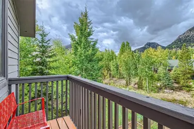 a balcony with a red chair and a view of a mountain at Hawn Drive 62 townhouse in Frisco