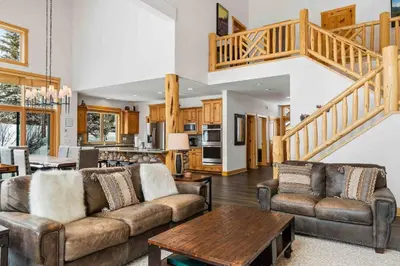 a living room with two couches and a table at Waterdance House home in Frisco