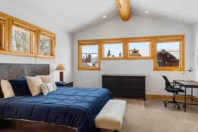 a bedroom with a bed and a desk and windows at Waterdance House home in Frisco