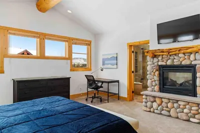 a bedroom with a bed and a fireplace and a tv at Waterdance House home in Frisco