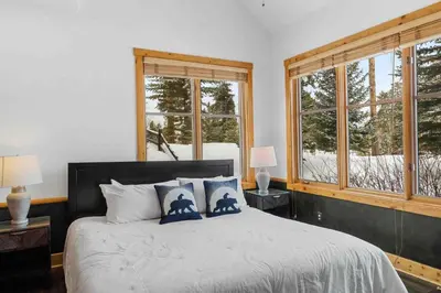 a bedroom with a large bed with two windows at Waterdance House home in Frisco