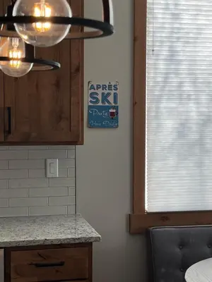 a kitchen with a sink and a chandelier and a window at Brand New! Private hot tub, bunk room and walkable to restaurants/shops in Fraser