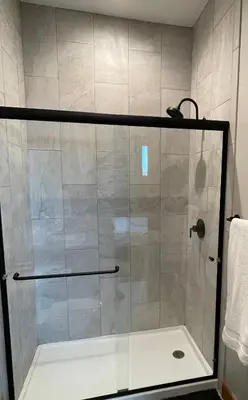 a shower with a glass door in a bathroom at Brand New! Private hot tub, bunk room and walkable to restaurants/shops in Fraser