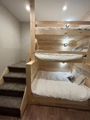 a bedroom with two bunk beds and a staircase at Brand New! Private hot tub, bunk room and walkable to restaurants/shops in Fraser