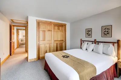 a bedroom with a large white bed with a wooden door at Beautiful 5br Home at The Ranch - Kids Ski Free! condo in Keystone