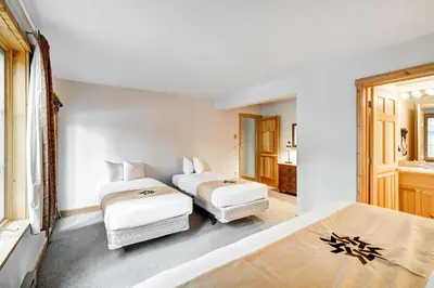 two beds in a room with white walls at Beautiful 5br Home at The Ranch - Kids Ski Free! condo in Keystone