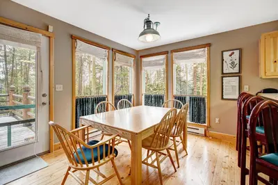 a dining room with a table and chairs and windows at Beautiful 5br Home at The Ranch - Kids Ski Free! condo in Keystone