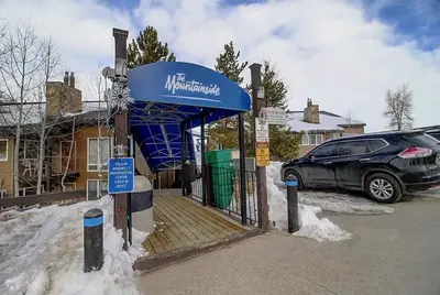 a car parked at a bus stop in the snow at New Listing - Slopeside condo with Private Hot Tub in Granby