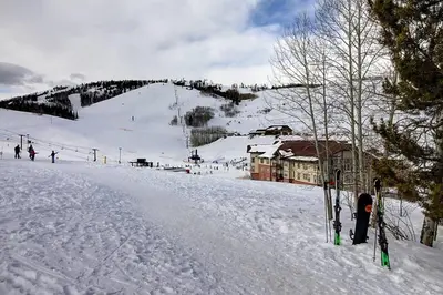 a person standing on a snow covered ski slope at New Listing - Slopeside condo with Private Hot Tub in Granby