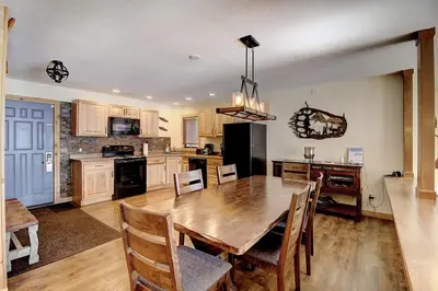 a kitchen with a wooden table and a dining room at New Listing - Slopeside condo with Private Hot Tub in Granby
