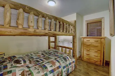 a bedroom with a wooden bunk bed and a dresser at New Listing - Slopeside condo with Private Hot Tub in Granby