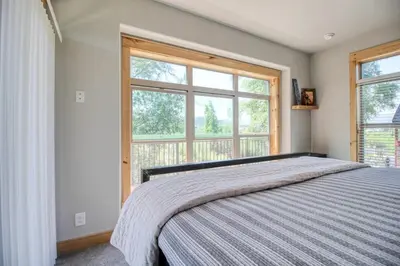 a bedroom with a bed and a large window at Modern 3bd cabin in Edgewater in Granby