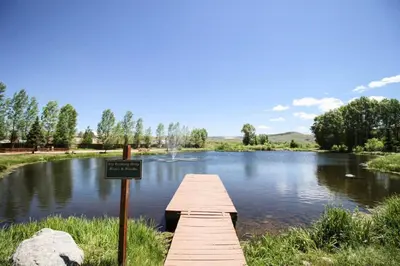 a wooden bridge over a lake with a sign at Modern 3bd cabin in Edgewater in Granby
