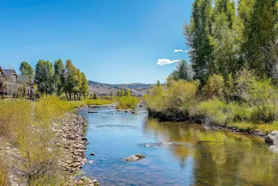 a river with rocks and trees in a field at Cozy 3 bedroom Mountain Getaway - Ski Fish Golf in Granby