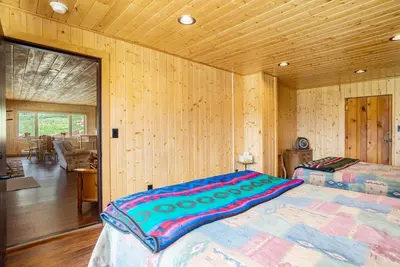 a bedroom with a bed in a room with wooden walls at Frontier Mountain Retreat - Monthly Long-Term Vacation Rental 30 Days Minimum -- Estes Park apts in Estes Park
