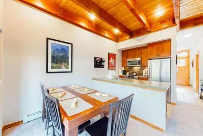 a dining room with a table and a kitchen at The Seasons Keystone 2 Bedroom In Lakeside Village in Keystone