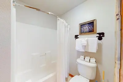a white bathroom with a toilet and a shower at The Seasons Keystone 2 Bedroom In Lakeside Village in Keystone