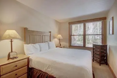 a bedroom with a large white bed and a window at 1 Bedroom Condo At The Springs In River Run Village in Keystone