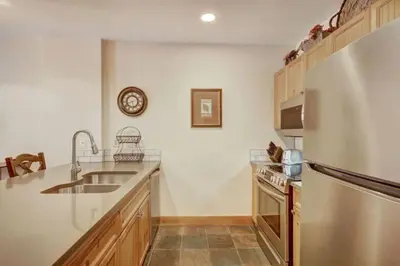 a kitchen with a sink and a refrigerator at 1 Bedroom Condo At The Springs In River Run Village in Keystone