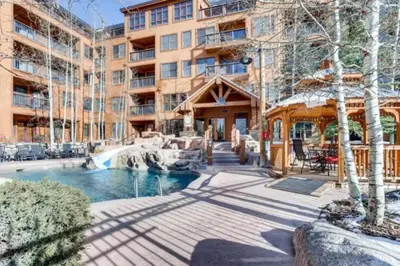 a hotel with a pool and a fountain in front of a building at 1 Bedroom Condo At The Springs In River Run Village in Keystone