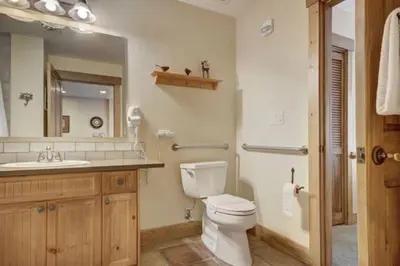 a bathroom with a toilet and a sink and a mirror at 1 Bedroom Condo At The Springs In River Run Village in Keystone
