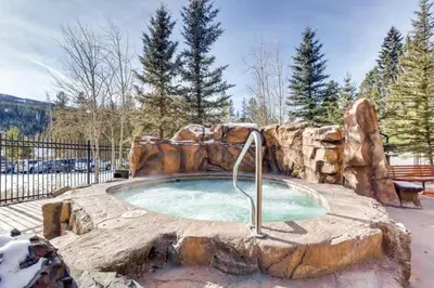 a small pool with a rock wall around it at 2 Bedroom Condo At The Springs In River Run Village in Dillon